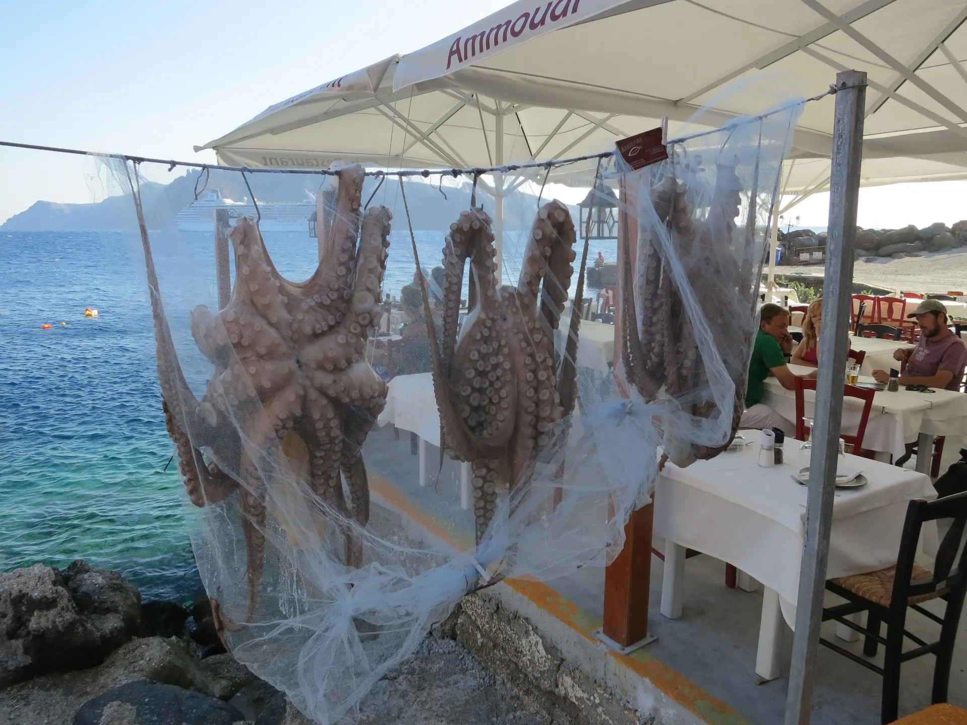 View of bay and octopus drying in Ammoudi Bay, Santorini.